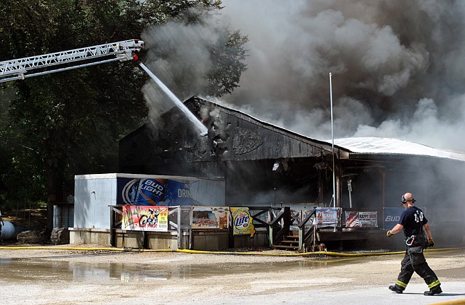 Firefighters angled many fire engine hoses toward various parts of the restaurant and neighboring residential units to control the blaze at Camp Bagnell Fish and Steakhouse.