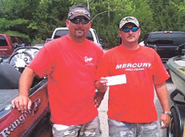 Two members of the Callaway Bass Anglers show off their first place check at the group's last outing at the Lake of the Ozarks on June 12. The Anglers next tournament is scheduled for July 9.