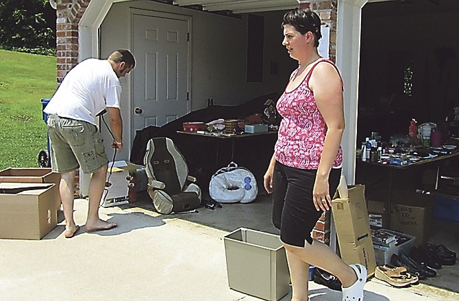 Andrew and Danielle Stammer, Joplin, organize their belongs for a garage sale at the home of Danielle's parents, Dale and Diana Otto. The Stammers lost their home in the May 22 tornado. 