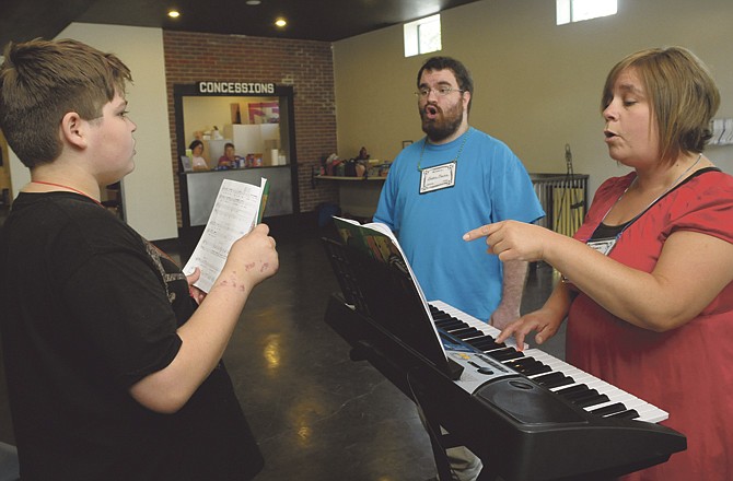 Isaac Watson, left, receives individual attention as he works on his solo for the play "The Game Plan" last Wednesday during Creative Arts Ministry Program or C.A.M.P. at Stained Glass Theater. Jill Walker, right, and Justin Martin, both with the music part of the program, worked two-on-one with the soloists as needed. 