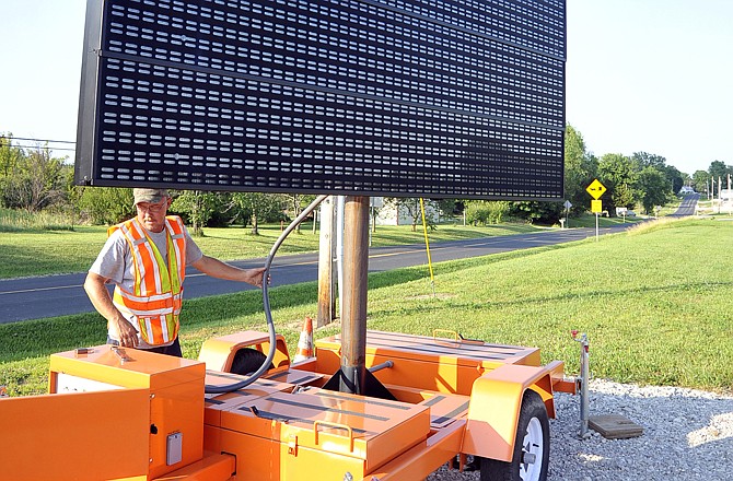 Missouri Department of Transportation worker Dan Goff installed a large sign in Jamestown last week. The sign warns motorist to seek an alternate route as floodwaters have closed Missouri 179, between Jamestown and Jefferson City.