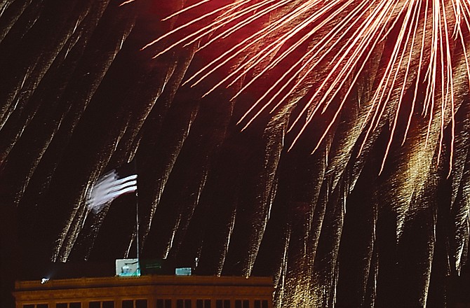 Fireworks burst above the flag atop Central Bank as the Salute to America ends Monday evening.