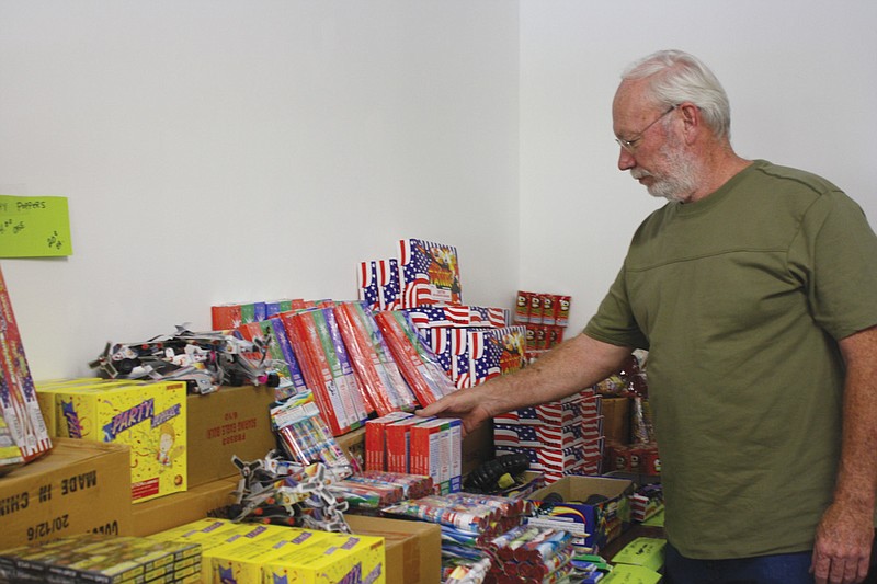 David Harrum, owner of the fireworks stand on Route NN just south of the Missouri Route H and U.S. 54 intersection in Fulton, checks his fireworks inventory Tuesday. Harrum said he may keep the stand open only for a day or so. He said sales this year at his location just outside Fulton were down a little, mainly because of increased competiton from new fireworks stands inside Fulton that are now legal.