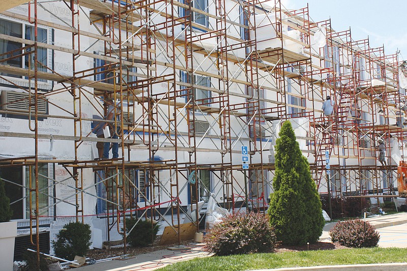 Workmen on scaffolds at the Holiday Inn Express, 2205 Cardinal Dr. in Fulton, are renovating the exterior of the hotel. It is part of a relaunching and upgrading of Holiday Inn hotels throughout the world.