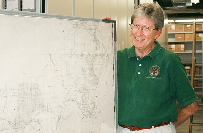 Lisa Fox, an archivist with the Missouri State Archives, shows an oversized map of a topographical survey of the swamp lands of southeast Missouri.