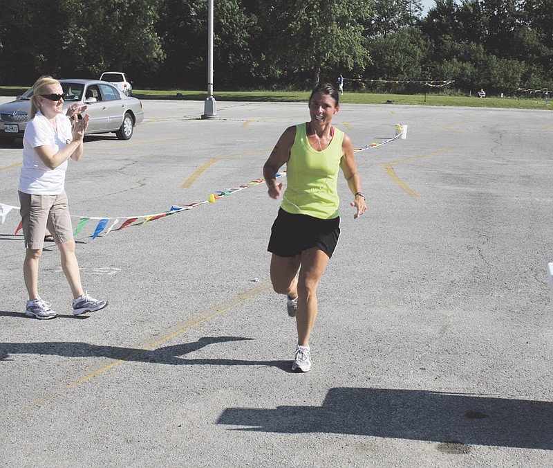 Kendra Pudlowski crosses the finish line to applause at the Fulton Triathlon on Saturday.