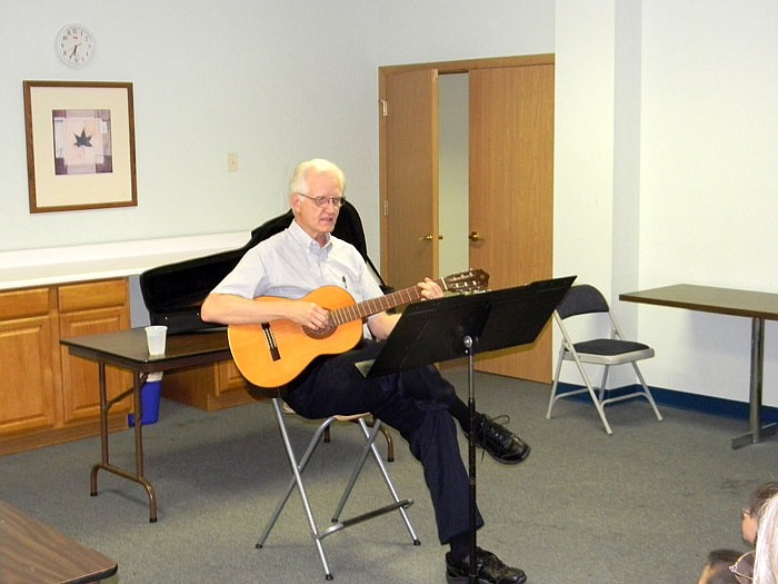 Phil Lewis plays one of many international folk songs for the children at Wood Place Public Library Thursday, July 7.