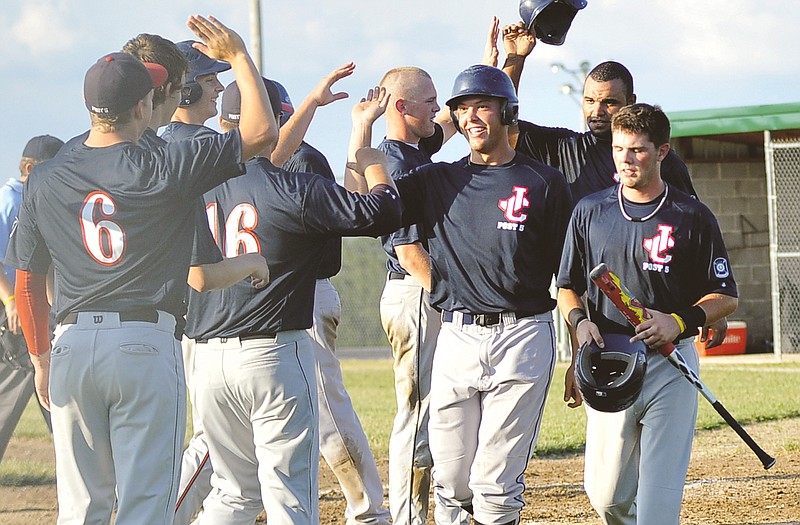 
Jeremy Geist (wearing helmet) of the Jefferson City American Legion Post 5 Senior team is greeted by his teammates after hitting a grand slam home run in the second inning of Wednesday night's district tournament game against Camdenton at the American Legion Post 5Sports Complex.