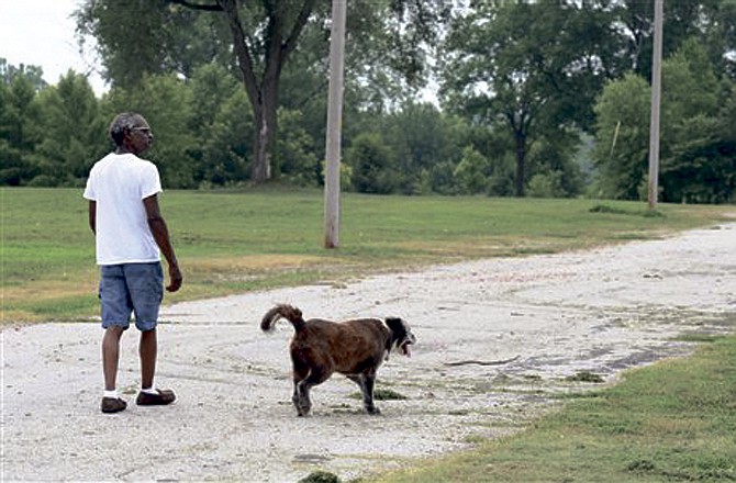 Maurice Lewis walks with his dog, Harley, in the former Cedar City area. Lewis lived was one of the few whose home was inhabitable after the flood of 1993. Numerous homeowners in the area were bought out, and now there are only a handful of homes in the area. (AP photo)