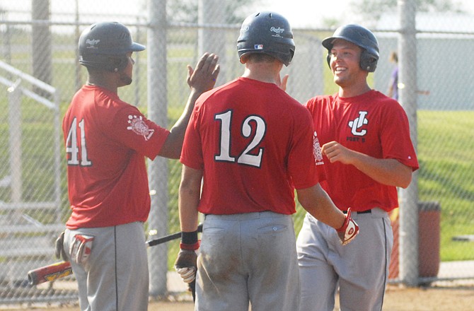Teammates for the Jefferson City Post 5 Seniors congratulate Jeremy Geist as he comes across home plate for his second home run of the game during a semifinal matchup against Fulton.