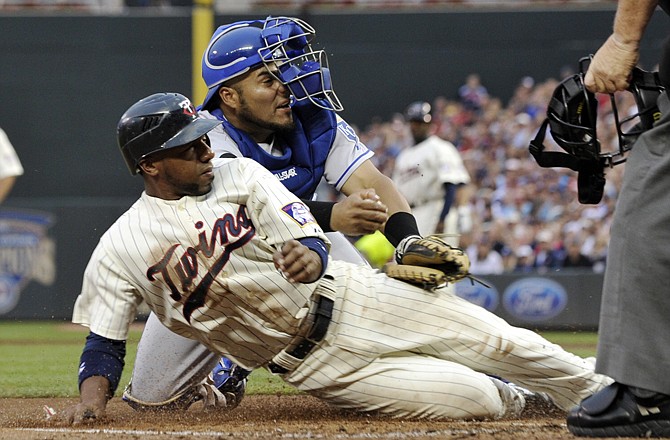 Minnesota's Alexi Casilla, left, is tagged out by Royals catcher Brayan Pena as he tried to score from third on a sacrifice fly by Danny Valencia in the first inning Thursday.