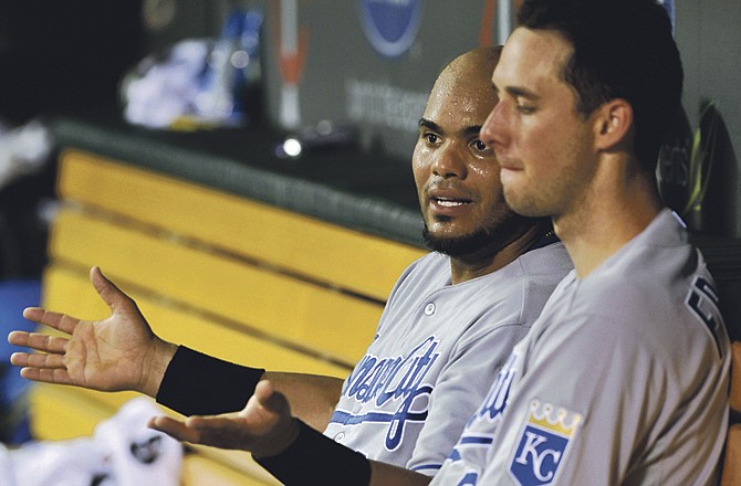 Kansas City Royals' Brayan Pena, left, visits with pitcher Jeff Francis in the dugout after Francis picked up the loss as the Minnesota Twins beat the Royals 4-3 in a baseball game, Saturday, July 16, 2011, in Minneapolis.