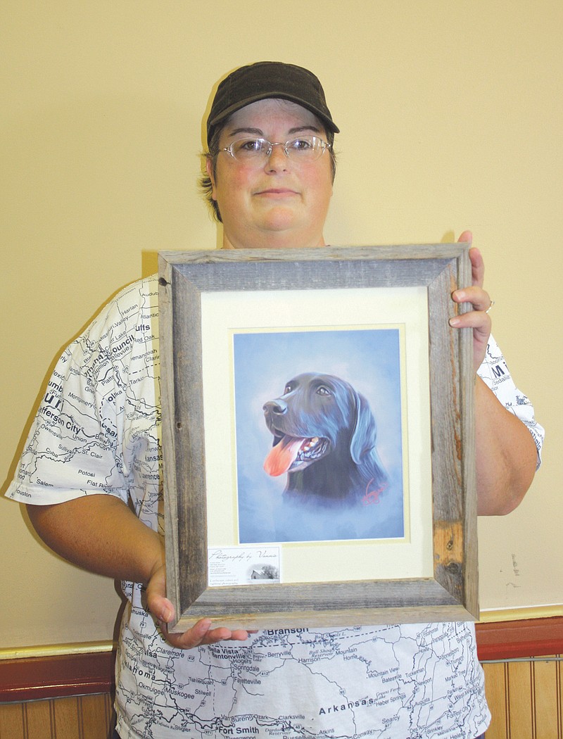 Vonnie Byars holds a portrait of Callaway County Humane Society canine mayor Chevy at Adorable Grooms on Friday.