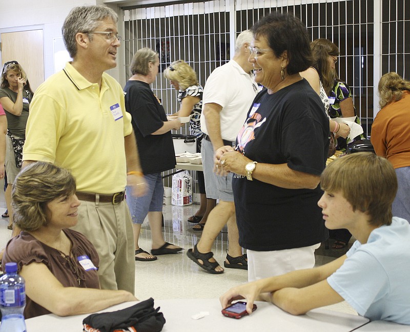 David Tramel, the new superintendent at the New Bloomfield R-3 school district, chats with Gracia Backer, president of the district's board of education during an informal welcoming dinner Monday at the school cafeteria. Seated are Tramel's wife Paulina and their son Garrett.