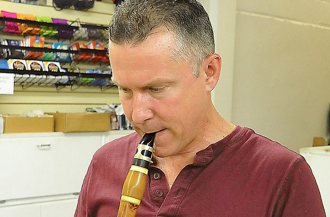 Bruce Connor plays a 19th century clarinet he restored at Capital Music. After years repairing instruments while also working as a band teacher, Connor has retired from teaching and now works on instruments full time.