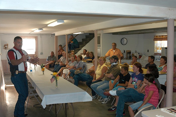 Sgt. Jason P. Clark of the Rural Crimes Investigative Unit, left, speaks to about 30 people in attendance at the Moniteau County Crime Watch meeting in Latham. 