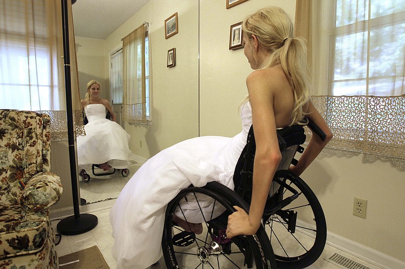 Rachelle Friedman looks in the mirror during the fitting for her wedding dress in Raleigh, N.C. Friedman was left paralyzed after a swimming pool accident that postponed her wedding plans.