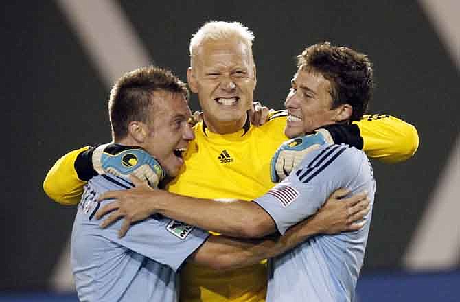 Sporting Kansas City goalkeeper Jimmy Nielsen, middle, celebrates with teammates Michael Harrington, left, and Matt Besler after beating the Portland Timbers 2-1 in their MLS soccer game in Portland, Ore., Saturday, July 2, 2011.