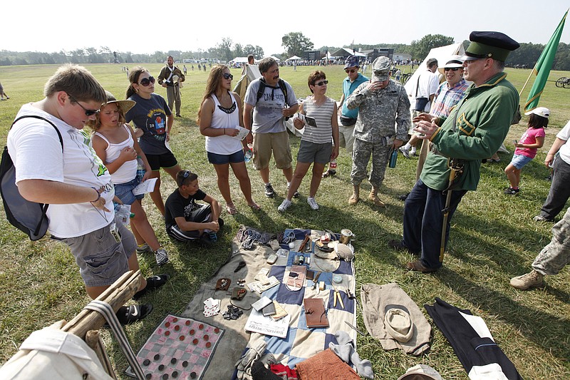 A Civil War re-enactor, right, talks about soldiers' supplies to visitors Thursday during the First Battle of Manassas 150th Anniversary Commemorative ceremony at the Manassas National Battlefield Park in Manassas, Va.