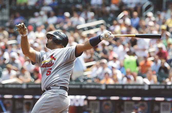 Albert Pujols of the Cardinals follows through on a two-run home run during the first inning of Thursday's game against the Mets in New York.