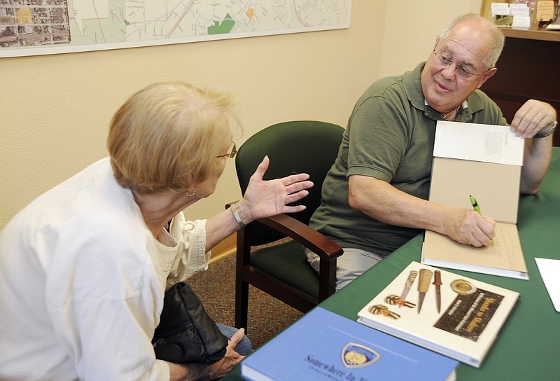 Local historian Mark Schreiber signs a copy of his latest book "Shanks to Shakers" for Jerre Purvis, Owensville, on Thursday afternoon at the Convention and Visitors Bureau on High Street.