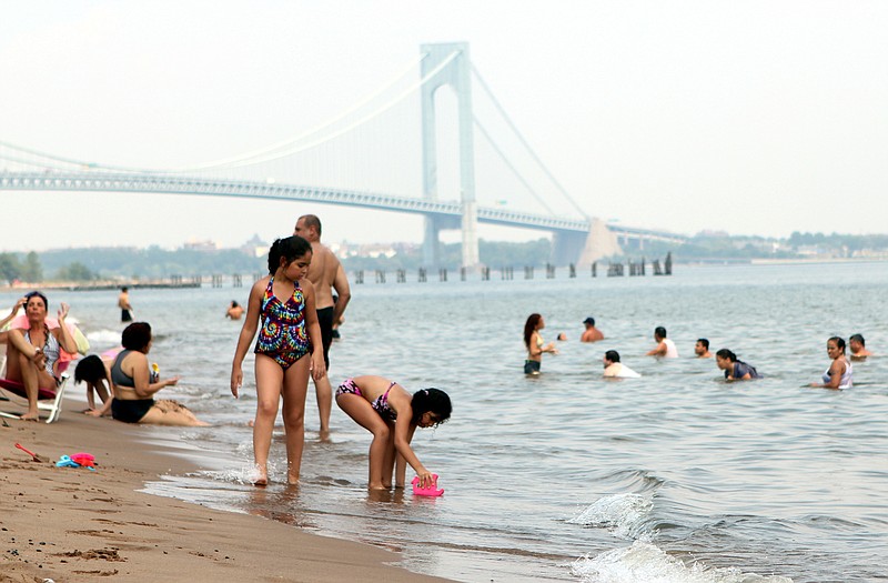 With temperatures soaring over 100 degrees in New York City, beachgoers ignore a warning by the city's health department Friday and take to the water on Staten Island's South Beach. 