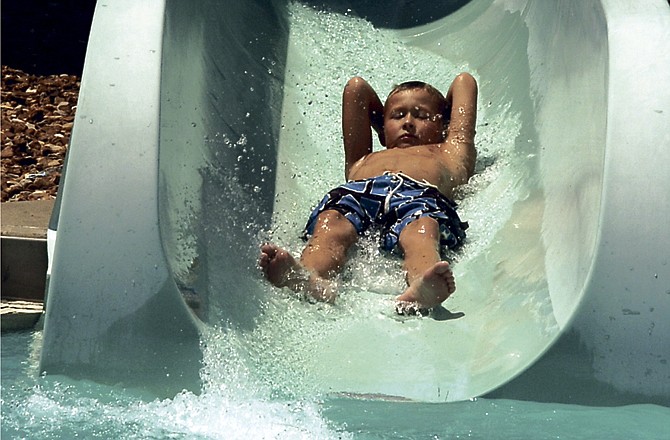 
Taylon Kennedy, 8, shoots down the slide Saturday at Jefferson City's Memorial Park Family Aquatic Center. Pool officials say the warm weather has warmed up the pool water, but patrons are still coming to take a dip. 