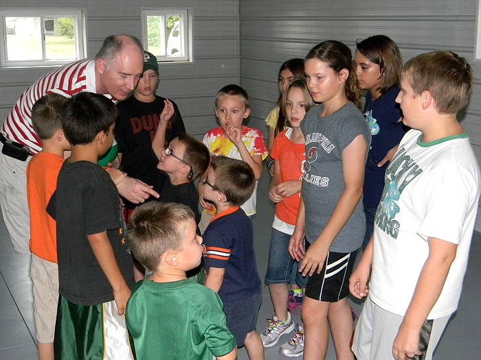 Lupus Baptist Church Pastor Tim Redmond helps get children ready to play dodgeball with beach balls during recreation.