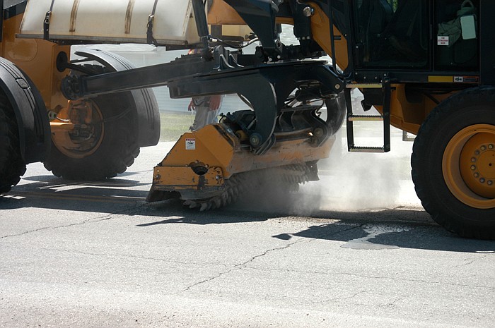 The MoDOT grinder shaves off a "blowup" to smooth Business Highway 50 near the City Park on Wednesday, July 20.