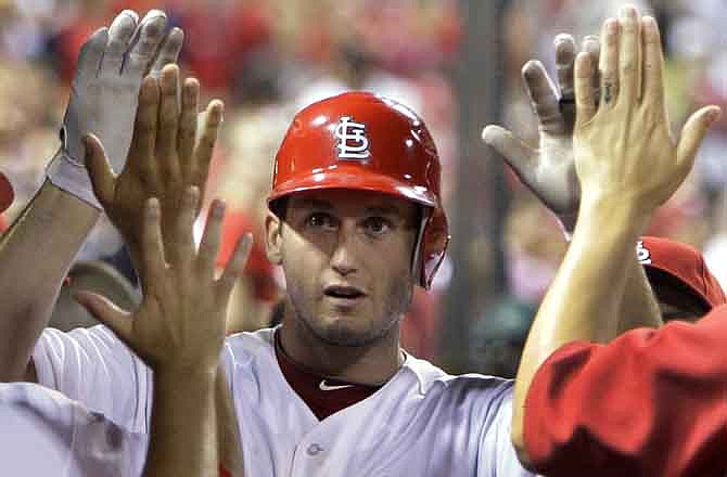 St. Louis Cardinals' David Freese is congratulated by teammates in the dugout after hitting a solo home run during the sixth inning of a baseball game against the Houston Astros on Tuesday, July 26, 2011, in St. Louis.