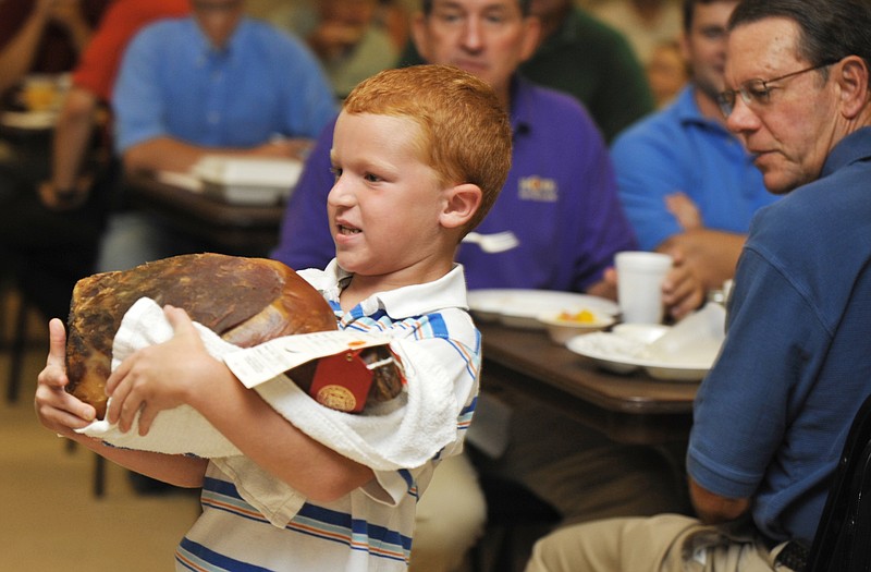 Levi Halvorson, 7, shows off his cured ham Friday at the annual Cole County Fair Breakfast and Ham Auction. 
