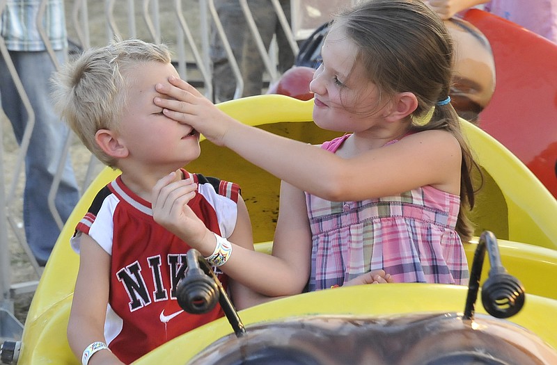 
Carleigh Hilgert, 7, and her 5-year-old brother, Joshua, share some sibling shenanigans on a ride Friday. 