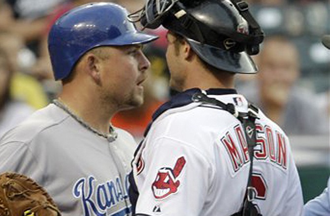 Kansas City's Billy Butler, left, is held back by Cleveland Indians catcher Lou Marson after Indians starting pitcher Carlos Carrasco threw a high inside pitch to Butler in the fourth inning in a baseball game on Friday, July 29, 2011, in Cleveland. Carrasco was ejected.