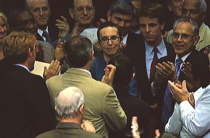 In this image from House Television, Rep. Gabrielle Giffords, D-Ariz., center, draws a warm welcome on the floor of the House of Representatives on Monday. Attending to vote on the debt compromise, it was her first time was on the floor since she was shot earlier this year.