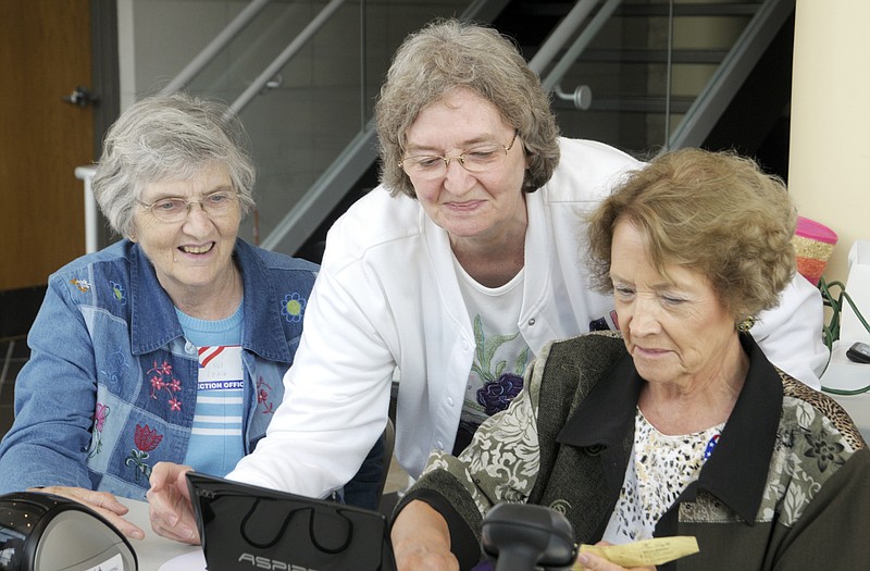 Polling judges Veldeva Long, left, Nancy Ottinger and Marjorie Smith sort through an issue with the license reader. As of 4 p.m., they had logged 36 voters at Miller Center polling place. 