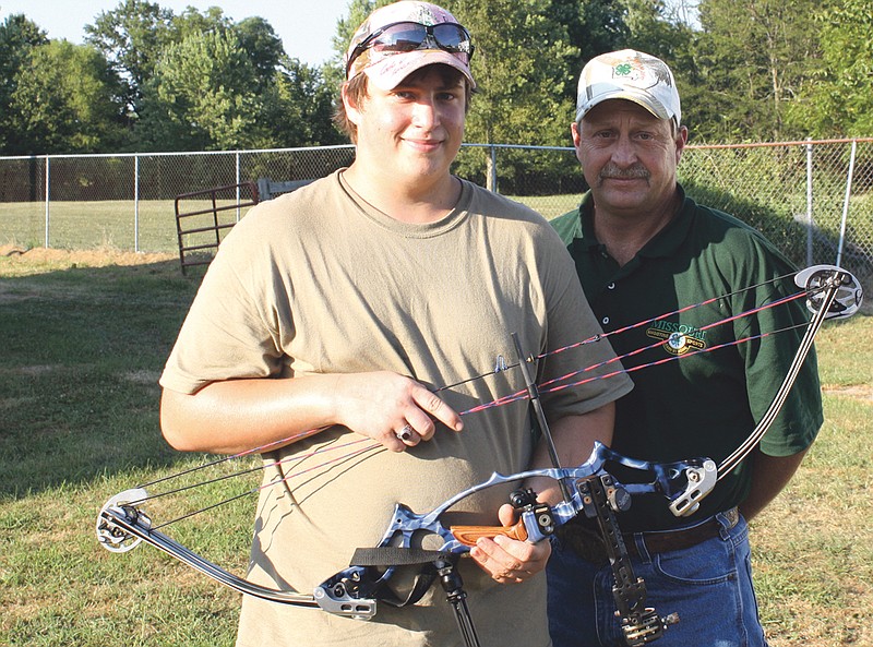 Shane Davis (left) and his father Jeff pose with Shane's archery bow at the Callaway County Fairgrounds on Monday.