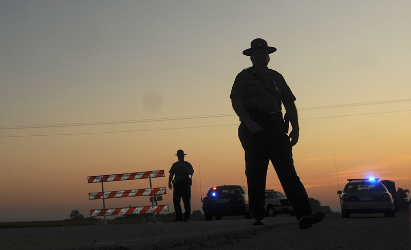 Sgt. Sheldon Lyon, right, spokesman for the Missouri State Highway Patrol and Cpl. Michael Belshe work at the intersection of Missouri highway 118 and state route P Monday evening in Holt County. A Missouri State Trooper and K-9 assigned to the water patrol division have been missing since Monday afternoon.