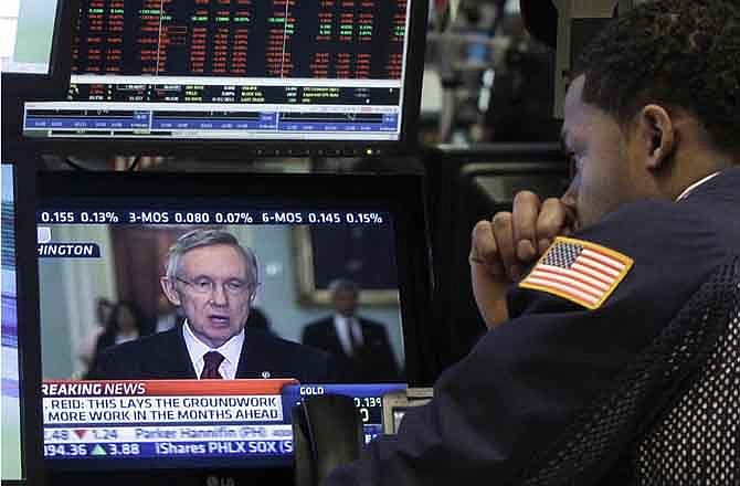 A specialist watches Sen. Harry Reid as he works on the floor of the New York Stock Exchange Monday, Aug. 1, 2011. 