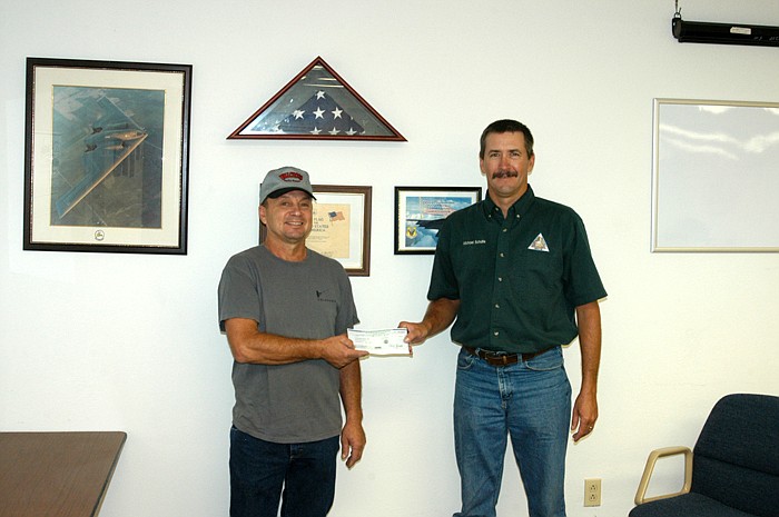 On behalf of the California Rural Fire Protection District, David Strobel accepts a check in the amount of $3,000 in matching funds from Missouri Department of Conservation Resource Technician Michael Schulte. The funds help update the fire district's communications.  