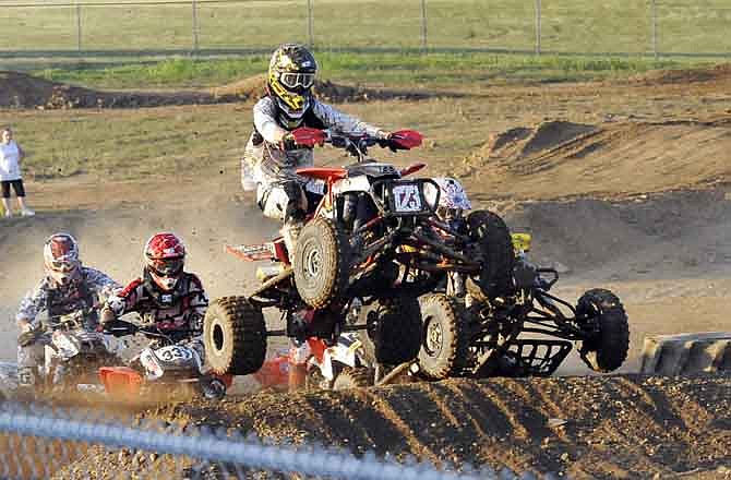 Several four wheelers vye to be first over the jump during a motocross event on July 25, 2011, at the Jefferson City Jaycees Cole County Fair.