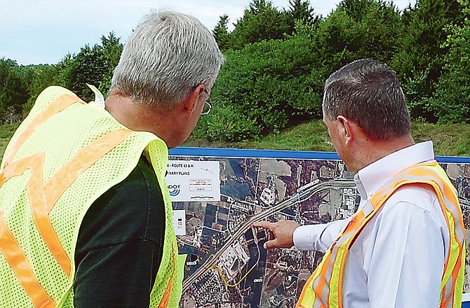 MoDOT chief engineer Dave Nichols, right, and businessman Ed Holt look at a map of the planned new interchange near the Columbia Airport after Monday's ground-breaking ceremony.