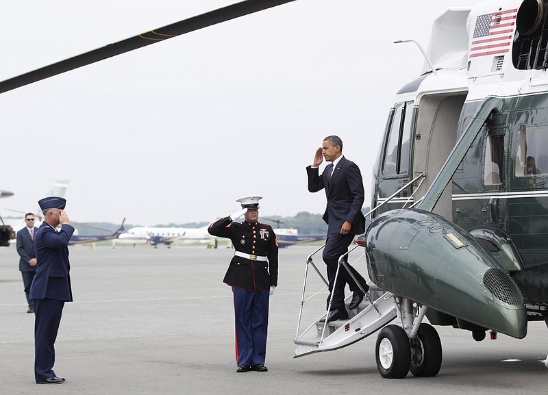 President Barack Obama salutes Tuesday as he is greeted by Col. Mark Camerer, left, commander of the 436th Airlift Wing, at Dover Air Force Base, Del. 
