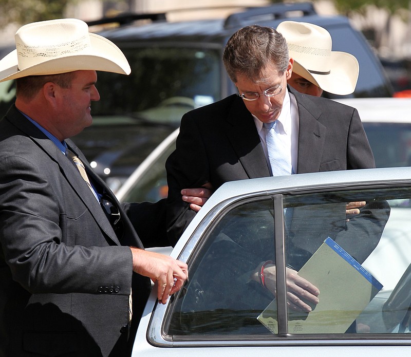 Warren Jeffs, right, leader of the Fundamentalist Church of Jesus Christ of Latter-day Saints, is placed into the back of a waiting car Tuesday in San Angelo, Texas. The polygamist leader was sentenced to life in prison for sexually assaulting two underage followers. 
