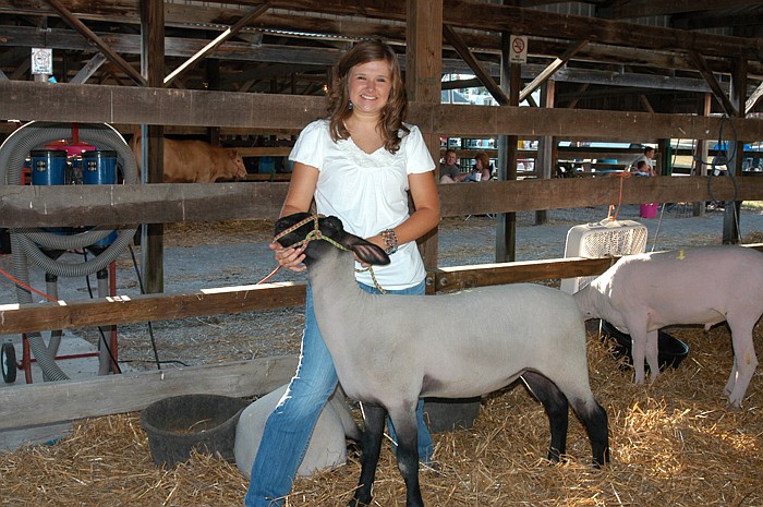 Rachel Oerly with her Grand Champion Market Lamb at the Moniteau County Fair Junior Livestock Auction. The lamb is a Suffolk.