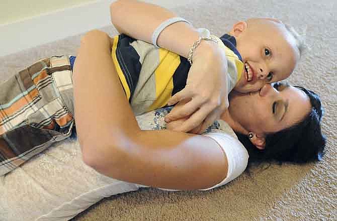 In this photo taken Aug. 1, 2011, Ashley Fallis kisses her son Blake Fallis, 3, while playing in their living room of their Evans, Colo. home. Blake was diagnosed with hyrdocephalus in 2009. One in 500 babies are affected by hydrocephalus, a condition the Fallises have learned a great deal about thanks to the Pediatric Hydrocephalus Foundation, which has chapters in 18 states. (AP Photo/The Greeley Tribune, Jim Rydbom)