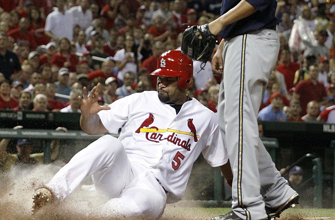 Albert Pujols of the Cardinals slides safely into home during the fifth inning of Thursday night's win over the Brewers in St. Louis.