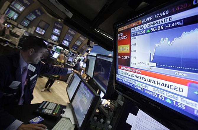 A television screen at the post of specialist Stephen Ruiz, left, displays the decision of the Federal Reserve, on the floor of the New York Stock Exchange Tuesday, Aug. 9, 2011. The Federal Reserve said Tuesday that it will likely keep interest rates at record lows for the next two years after acknowledging that the economy is weaker than it had thought and faces increasing risks. 