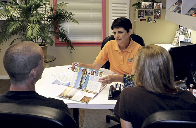 Helen Kliethermes meets with clients Friday to discuss travel plans at Travel Answers in Jefferson City.