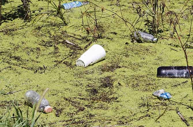 In this Aug. 10, 2011 photo, algae and trash float in a flooded field near Pacific Junction, Iowa. The Missouri River will slowly recede for the next couple of months and landowners are bracing for what's left behind. They expect to find deep sand, dead fish and lots of junk swept downstream by the highest floodwaters seen in more than 50 years.