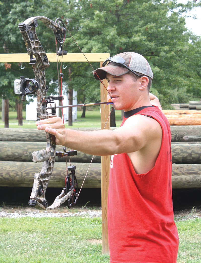 Brant Masek, 20, of Fulton, aims at a target on Friday in the new city Archery Center. Masek visits the range to practice shooting with his bow.